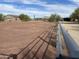 View of a fenced horse paddock with desert landscaping and other buildings on the property at 7100 E Montgomery Rd, Scottsdale, AZ 85266