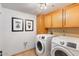 Bright laundry room features a washer, dryer, and light wood cabinetry for storage at 7100 E Montgomery Rd, Scottsdale, AZ 85266