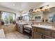 Bright bathroom featuring dual sinks, a vanity area, tile backsplash, and plenty of natural light at 7100 E Montgomery Rd, Scottsdale, AZ 85266