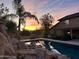 Backyard oasis featuring a gorgeous pool, palm tree, and inviting seating area with stunning desert sunset views at 7100 E Montgomery Rd, Scottsdale, AZ 85266