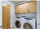 Bright laundry room with stacked, front-loading washer and dryer and ample cabinet storage at 7121 E Rancho Vista Dr # 5011, Scottsdale, AZ 85251