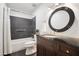 Modern bathroom with dark tile, updated vanity, a round mirror, and well-maintained fixtures at 7126 N Via Nueva --, Scottsdale, AZ 85258