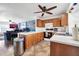 Modern open kitchen with wood cabinets, white counters, and a stainless steel trash can at 7905 W Thunderbird Rd # 308, Peoria, AZ 85381