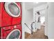 Bright red, modern, stacked washer and dryer unit near staircase landing at 7905 W Thunderbird Rd # 308, Peoria, AZ 85381