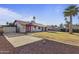 Spacious backyard featuring a mature palm tree, gravel area, and covered patio at 840 E Hackamore St, Mesa, AZ 85203