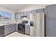 Galley kitchen with painted cabinets, tile floors, a double basin sink, and stainless-steel appliances at 840 E Hackamore St, Mesa, AZ 85203