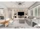 Bright living room featuring a large gray sofa, stylish decor, and a sleek media wall for a modern living experience at 8418 W Louise Ct, Peoria, AZ 85383