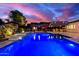 The sparkling blue pool complements lush landscaping and a covered patio for outdoor enjoyment at 8418 W Louise Ct, Peoria, AZ 85383