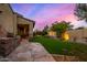 Picturesque backyard featuring a stone patio, built-in grill, and manicured lawn area, perfect for outdoor living at 9955 E Celtic Dr, Scottsdale, AZ 85260