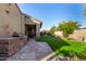 Outdoor patio with a stone outdoor kitchen, green lawn, and garden at 9955 E Celtic Dr, Scottsdale, AZ 85260