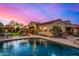 Backyard view features a pool, patio furniture, beautiful greenery, and an expansive twilight sky at 9955 E Celtic Dr, Scottsdale, AZ 85260