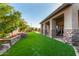 Inviting backyard space features a covered patio, manicured lawn and flower beds perfect for outdoor living at 9955 E Celtic Dr, Scottsdale, AZ 85260