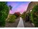 Beautifully landscaped backyard pathway with vibrant flowering bushes, leading towards more of the tranquil yard at 9955 E Celtic Dr, Scottsdale, AZ 85260