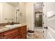 A well-lit bathroom showcasing a granite-topped vanity and a walk-in shower with decorative tile surround at 9955 E Celtic Dr, Scottsdale, AZ 85260