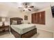 Cozy bedroom with a comfortable bed, wooden headboard, ceiling fan, and window with shutter blinds for privacy at 9955 E Celtic Dr, Scottsdale, AZ 85260