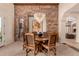 Elegant dining room featuring stone accent wall, decorative chandelier, and seating for six at 9955 E Celtic Dr, Scottsdale, AZ 85260