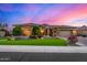 Beautiful single-story home with manicured lawn, stone accents, and tile roof at sunset at 9955 E Celtic Dr, Scottsdale, AZ 85260