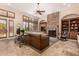 Inviting living room featuring a stone fireplace, wood built-ins, and plantation shutters at 9955 E Celtic Dr, Scottsdale, AZ 85260