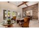 Open-concept living room features exposed beam ceiling, brick accent wall, and views to the backyard at 9955 E Celtic Dr, Scottsdale, AZ 85260