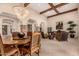 Spacious living room with exposed beam ceiling, large chandelier, and decorative stone pillars at 9955 E Celtic Dr, Scottsdale, AZ 85260