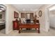 Well-lit home office with wood desk, shutters and a large clock; it also includes views into the open-concept living area at 9955 E Celtic Dr, Scottsdale, AZ 85260