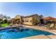 Sparkling swimming pool and spa surrounded by a concrete deck, lounge chairs, mature trees, and shade umbrellas at 9955 E Celtic Dr, Scottsdale, AZ 85260