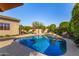 Beautiful sparkling swimming pool and stone waterfall feature with a landscaped yard provides a serene oasis at 9955 E Celtic Dr, Scottsdale, AZ 85260