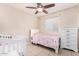 Bedroom with single bed, crib, dresser, ceiling fan, and tile floors at 1004 S Ironwood Dr, Apache Junction, AZ 85120