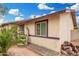 Charming home with desert landscaping including mature palm tree and sculpted planters at 1004 S Ironwood Dr, Apache Junction, AZ 85120