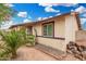 Charming home with desert landscaping including mature palm tree and sculpted planters at 1004 S Ironwood Dr, Apache Junction, AZ 85120