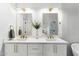 Double vanity bathroom with bright lighting, modern gold fixtures, quartz countertops and neutral walls at 10215 E Hillery Dr, Scottsdale, AZ 85255