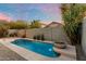 Beautiful pool with rock water feature, pebble rock landscaping, palm trees and privacy wall at 10215 E Hillery Dr, Scottsdale, AZ 85255