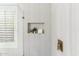 The bathroom shower features neutral tiling, niche shelving, and modern gold fixtures at 10215 E Hillery Dr, Scottsdale, AZ 85255