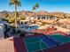 Aerial view of a backyard featuring a pool, sport court, mature landscaping, and mountain views at 10301 N 128Th St, Scottsdale, AZ 85259