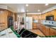 Traditional kitchen with wooden cabinets, tile countertops, and a view to the living room at 10301 N 128Th St, Scottsdale, AZ 85259