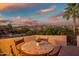 Outdoor patio with sunset views, a table with chairs, and a desert landscape at 10301 N 128Th St, Scottsdale, AZ 85259