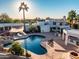 Aerial view of a backyard featuring a sparkling pool, lounge chairs, a rock waterfall, and desert landscape at 10301 N 128Th St, Scottsdale, AZ 85259