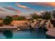 Swimming pool with rock waterfall feature surrounded by mature landscaping at 10301 N 128Th St, Scottsdale, AZ 85259