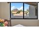 Window view of a desert landscape featuring a pool, rock features, and mountains in the distance at 10301 N 128Th St, Scottsdale, AZ 85259