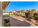 Cozy backyard with a desert landscape, small bridge, patio seating, and outdoor fireplace at 1031 W Indian Hills Pl, Phoenix, AZ 85023