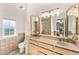 Bathroom featuring dual sinks, decorative mirrors, and a tiled shower with glass door at 1031 W Indian Hills Pl, Phoenix, AZ 85023