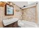 Well-lit bathroom with tiled shower/tub, single sink vanity, and updated fixtures at 1031 W Indian Hills Pl, Phoenix, AZ 85023