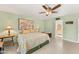 Cozy bedroom featuring a floral comforter, ceiling fan, tile floors and an ensuite bathroom at 1031 W Indian Hills Pl, Phoenix, AZ 85023