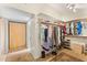 Spacious walk-in closet with built-in shelving, hanging rods, and carpeted flooring at 1031 W Indian Hills Pl, Phoenix, AZ 85023