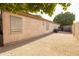 Low maintenance backyard area featuring durable gravel cover, stucco wall, and gated access, offering privacy and security at 1054 W Park Ave, Gilbert, AZ 85233