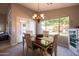 Warm dining room featuring a wood table, decorative chandelier, and ample natural light from the large backyard window at 1054 W Park Ave, Gilbert, AZ 85233