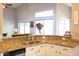 Bright kitchen featuring granite countertops, stainless steel sink, and a large window overlooking the backyard at 1054 W Park Ave, Gilbert, AZ 85233