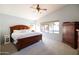 Serene main bedroom featuring a king-size bed, a ceiling fan, and views of the backyard pool at 1054 W Park Ave, Gilbert, AZ 85233