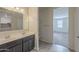 Bathroom with double vanity, storage shelving, and view into bedroom at 10705 E Sunflower Ct, Florence, AZ 85132