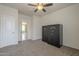 A bedroom with neutral carpet, featuring a ceiling fan, and two large, black safes at 10705 E Sunflower Ct, Florence, AZ 85132